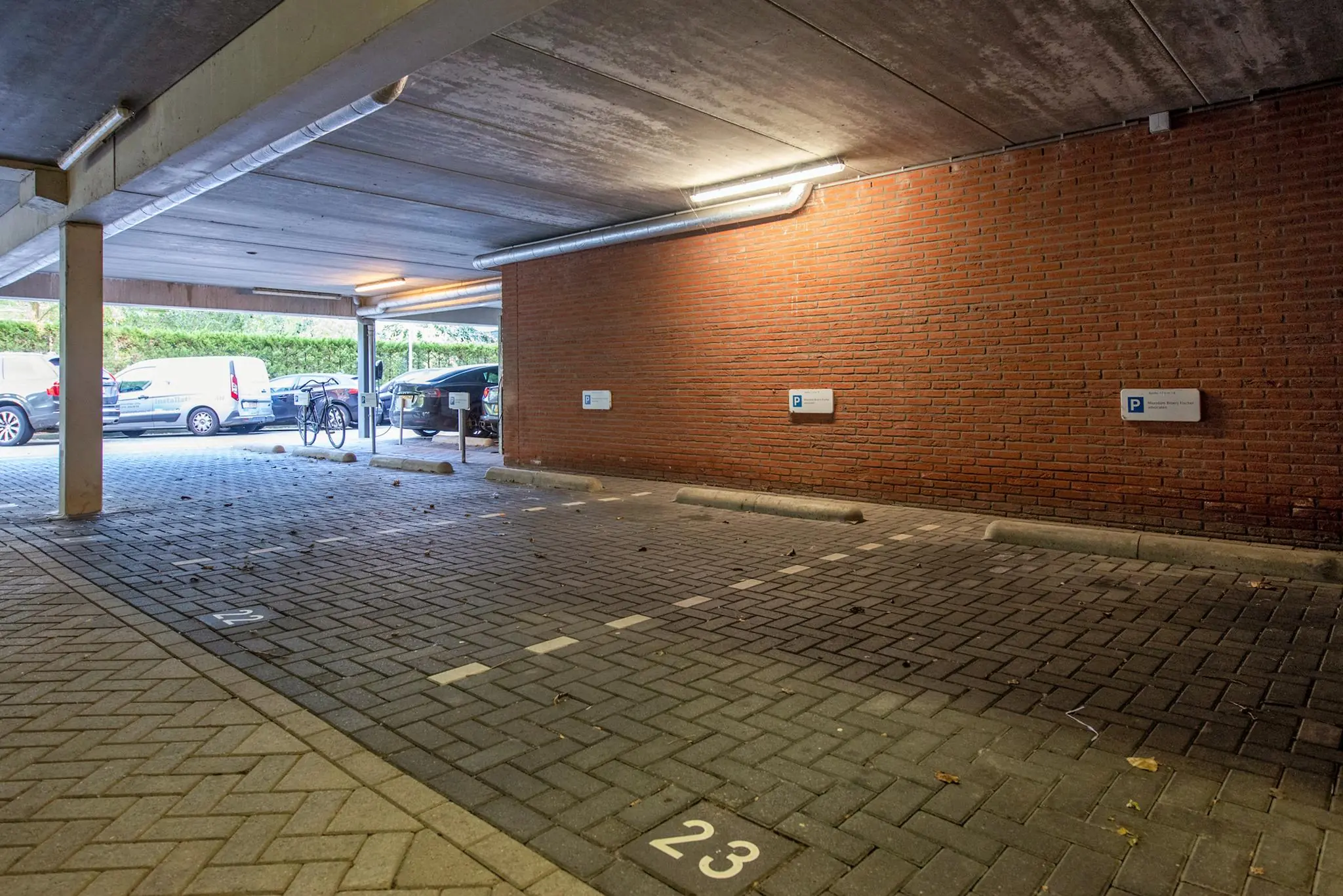 Overdekte parkeerplaats op de Laan van Vredenoord met gemarkeerde plek nummer 23.